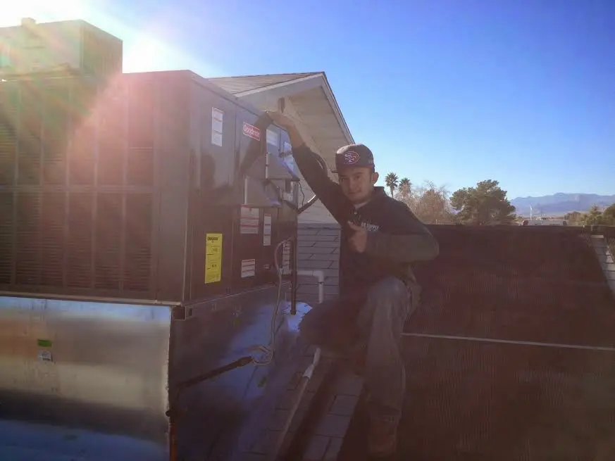 HVAC technician performing Heat Pump Repair on a rooftop unit in Richmond Heights
